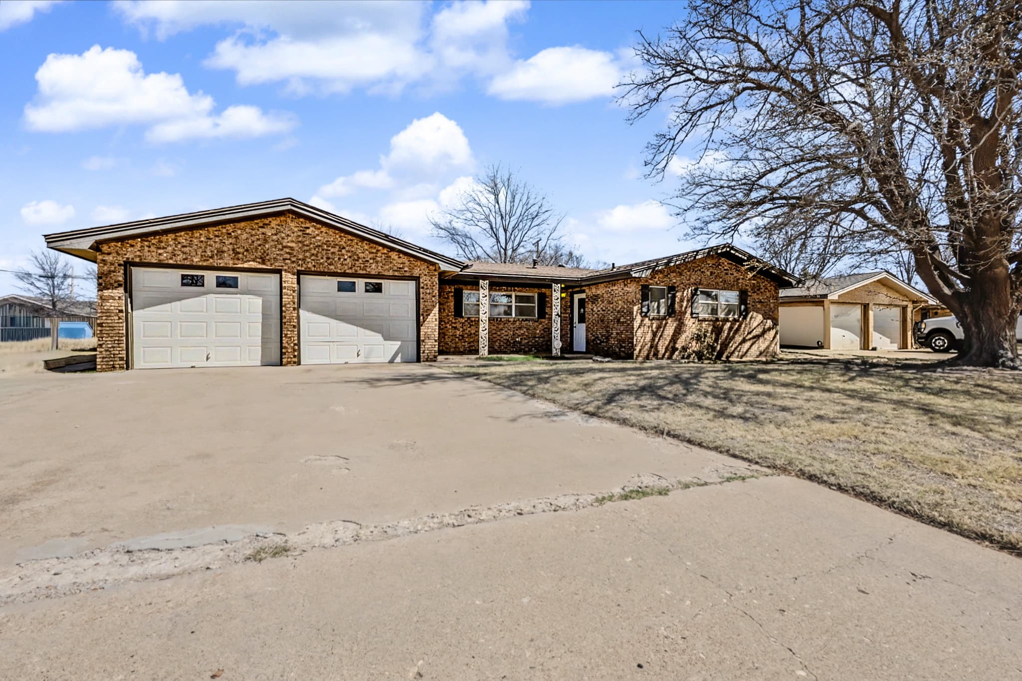 Single-story brick ranch home exterior in Levelland, TX with attached garage, photographed in hand-blended HDR.