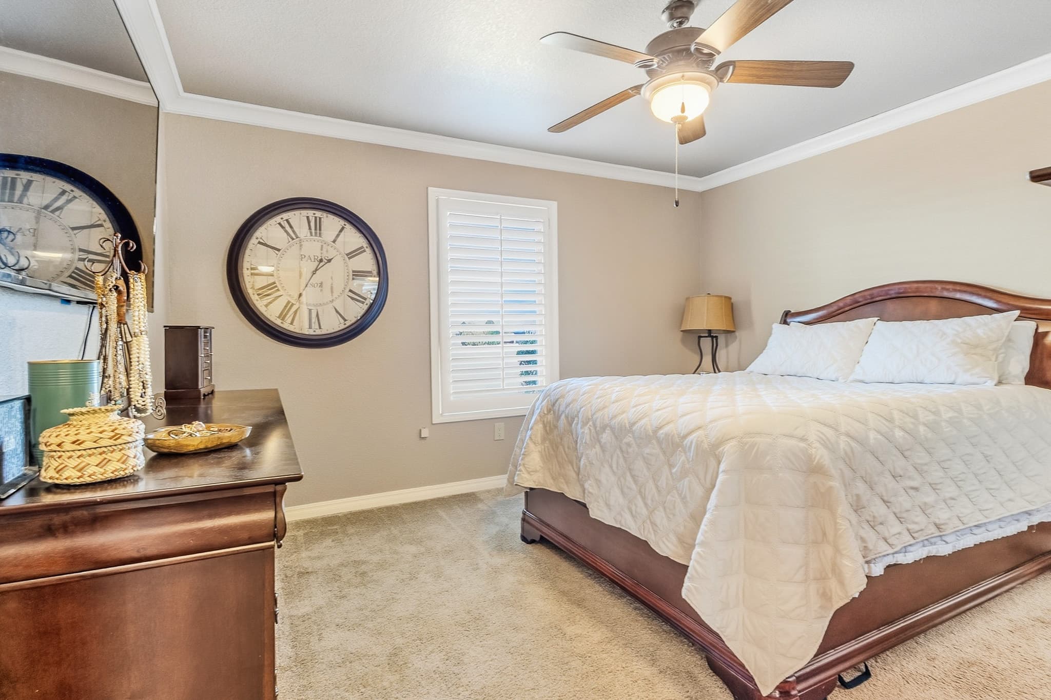 Primary bedroom suite in a Muleshoe, TX listing with neutral palette, crown molding, and natural window light.