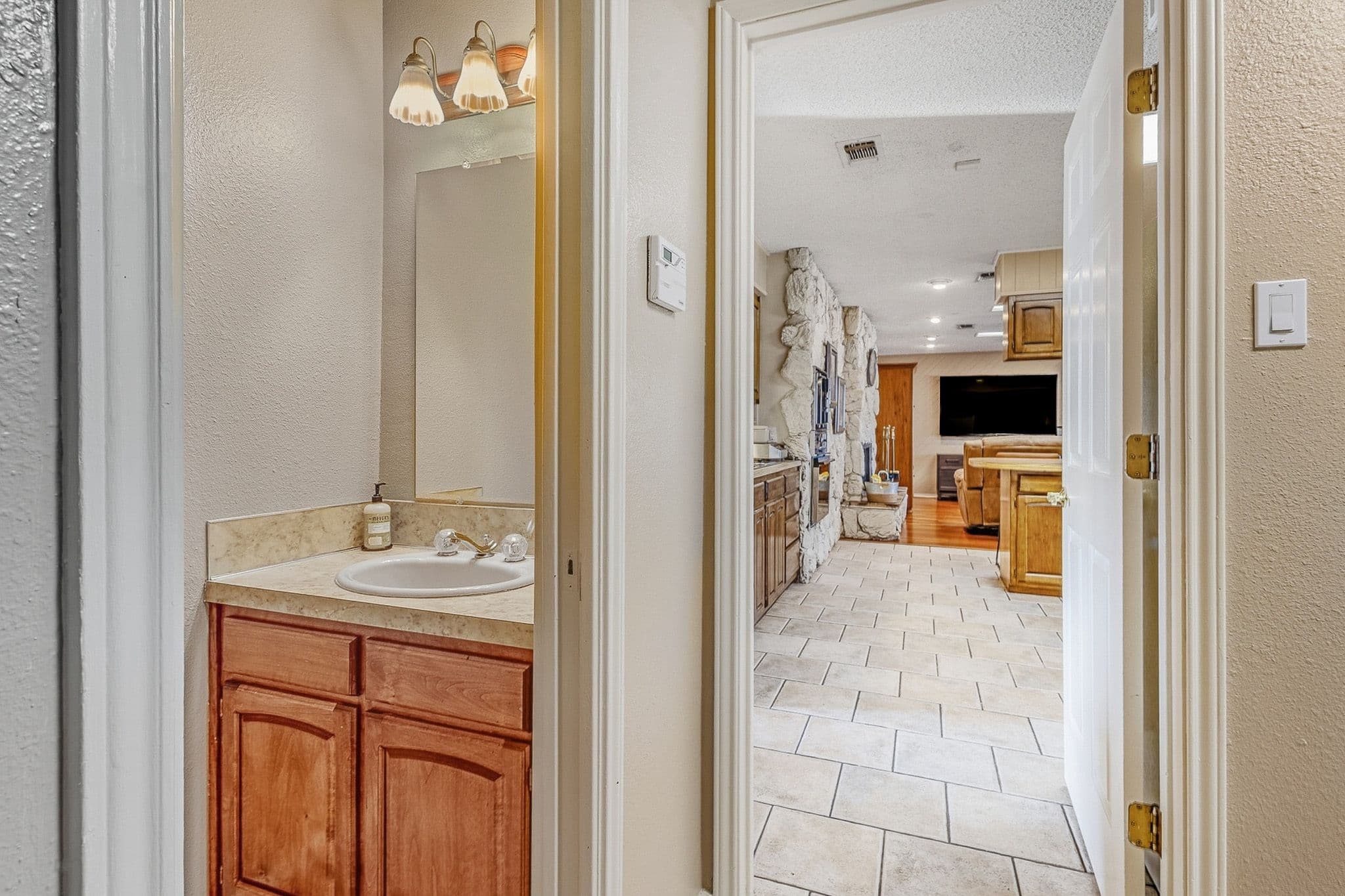 Interior shot of restroom and living room in background