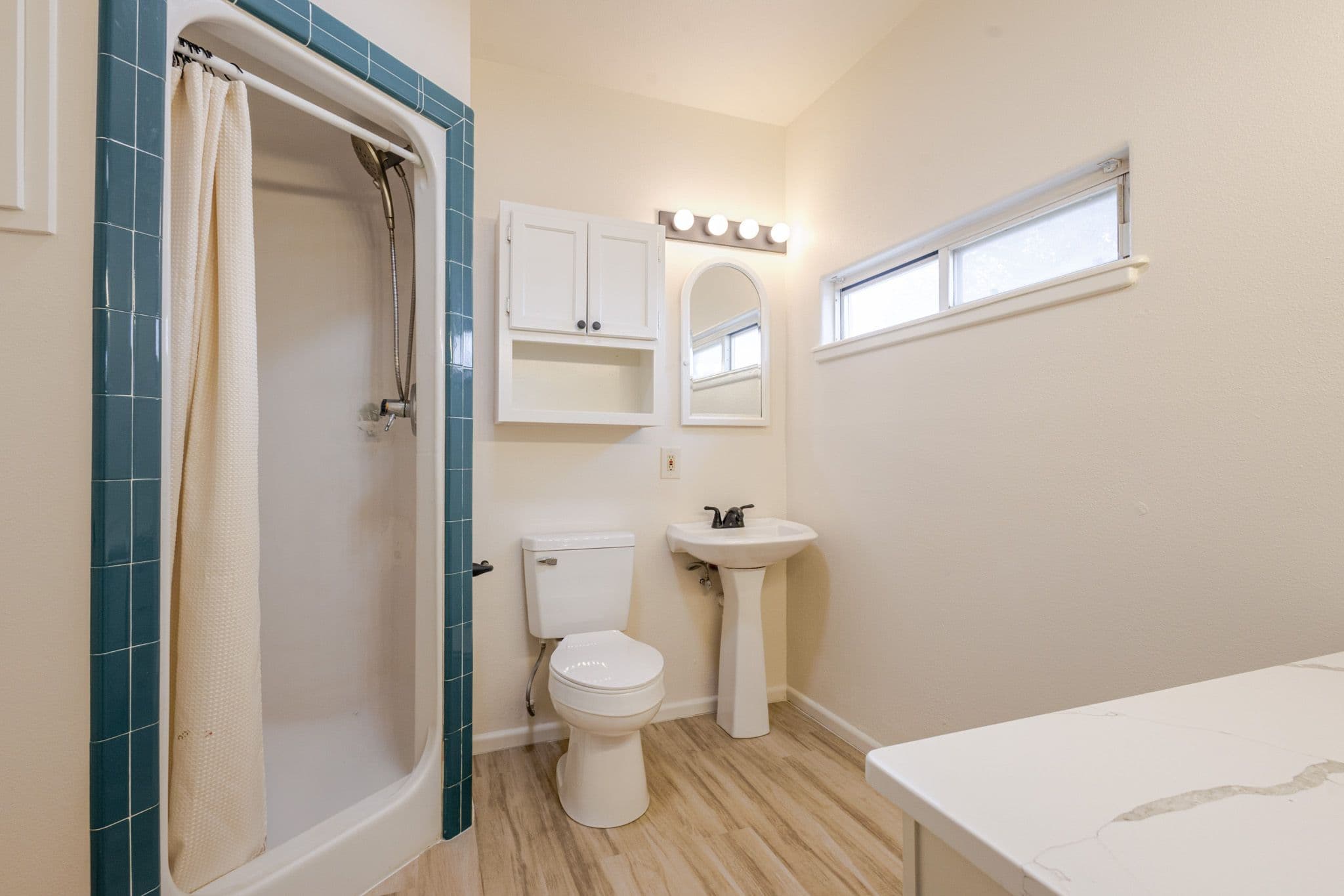 Interior shot of primary bathroom facing the standing shower and sink