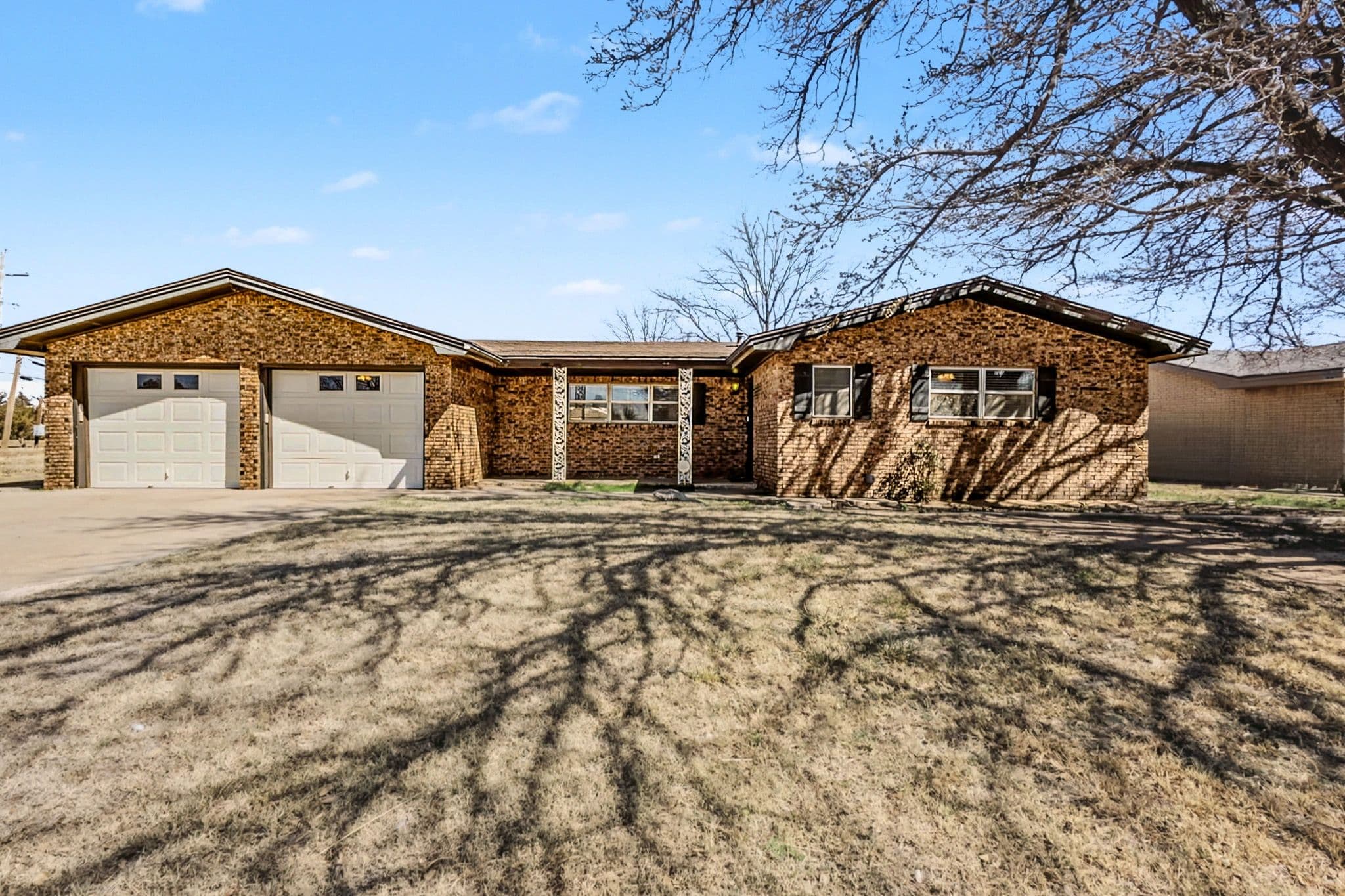 Bright open living room in a Levelland, TX ranch listing with natural light and clear sightline to the kitchen.